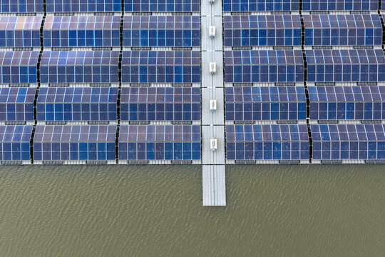 Aerial view of rows of floating solar panels on a water surface with central walkways and symmetrical patterns Beilen, Drenthe, Netherlands.