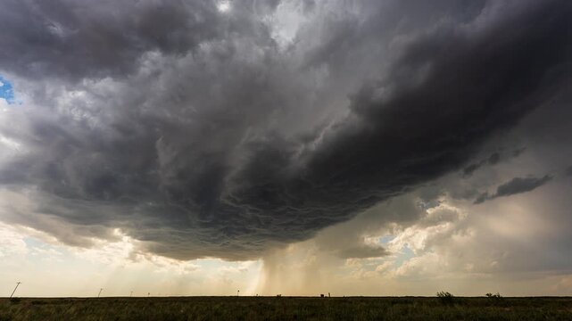 Severe weather clouds building over open landscape before rainstorm