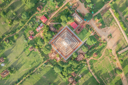 Aerial view of the ancient pagoda with its tiered square base surrounded by lush greenery and smaller temples in Old Bagan, Mandalay Region, Myanmar Burma.