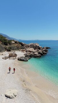 Discover the picturesque beaches of Kas in Antalya, Turkey, where golden sands meet crystal-clear waters. A couple of man and woman walking on the beach in Turkey during vacation