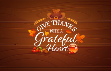 Obraz premium Give thanks with a grateful heart Thanksgiving greeting card quote. Vector message on wooden background with autumn leaves, wheat, berries, honey and pilgrim hat, expressing seasonal harvest gratitude