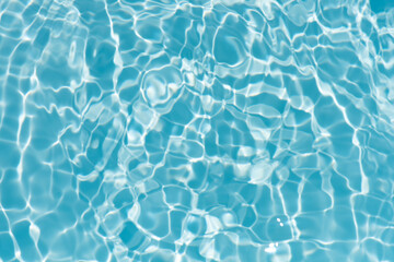 Obraz premium Blue water with ripples on the surface. Defocus blurred transparent blue colored clear calm water surface texture with splashes and bubbles. Water waves with shining pattern texture background.