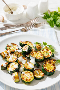 Fried zucchini with garlic yogurt sauce on plate