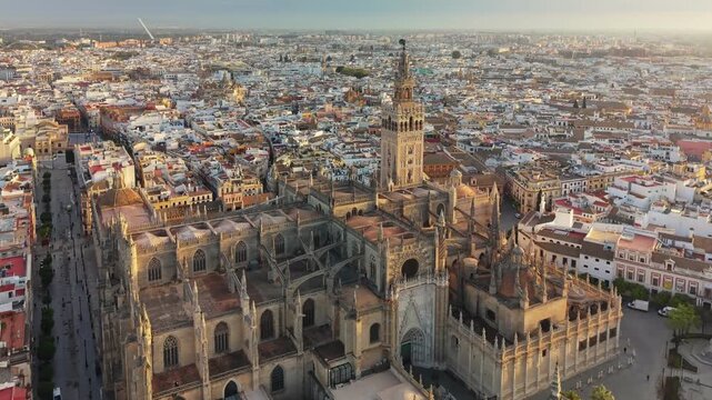 Stunning aerial view of majestic Seville Cathedral during golden hour, Seville, Spain. Giralda tower stands tall over the historic city landscape of Andalusia 