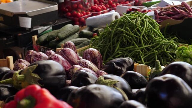 Close view of a traditional Italian market stall filled with fresh vegetables and local produce during a busy daytime shopping scene outdoors.