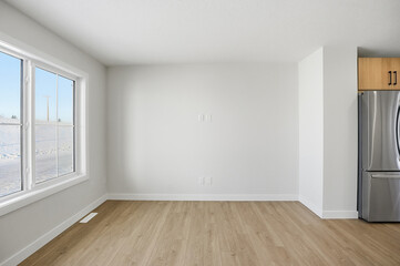 Fototapeta premium Large empty room with a window and a silver refrigerator