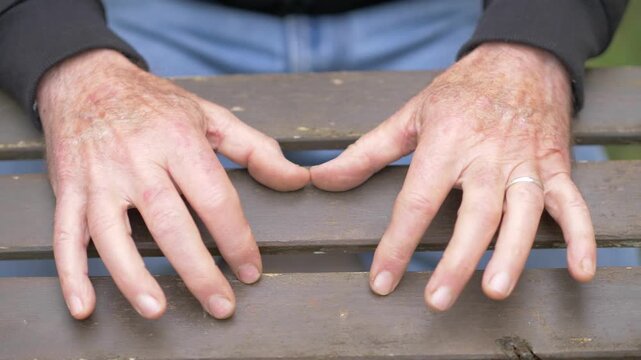 Overhead close-up of male hands tapping nervously on a table, expressing anxiety, impatience and inner tension through repetitive restless movement.