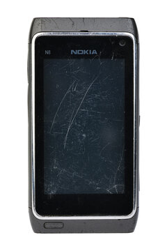 Old broken Nokia N8 smartphone isolated on a white background.