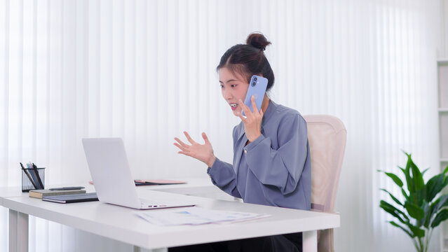 Asian businesswoman talking phone call video conference meeting remote working from home office desk using laptop computer gesture communicate online business