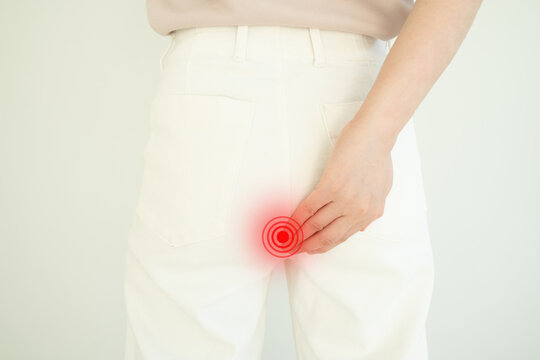 Woman suffering from anal pain and discomfort. Cause of pain include hemorrhoid, anal fissure, diarrhea, constipation or Crohn's disease. Gastrointestinal system concept.