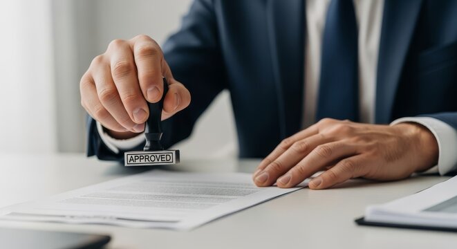 Businessman stamps an 'Approved' document, signifying official authorization and business agreement