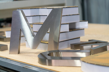 Close Up Stainless Steel Channel Letter Fabrication in Sign Workshop © Omimo