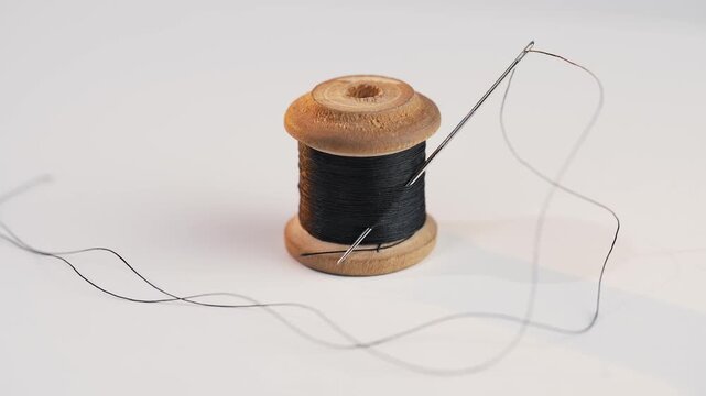 Black thread with needle on white background isolated