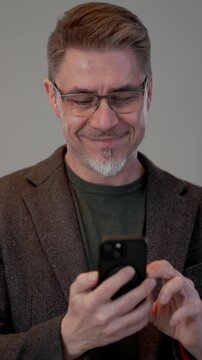 Middle age businessman in business casual using phone. Entrepreneur in jacket. Portrait of mid adult, mature age man, happy smiling. Isolated on white.