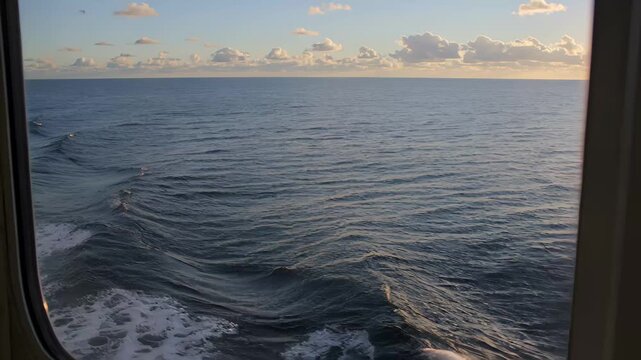 View of the ocean and horizon from a ferry window during sunset