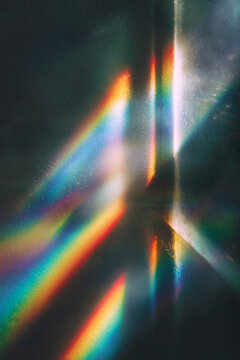 Dispersi&oacute;n de luz de prisma arco&iacute;ris abstracto con vetas de espectro de colores sobre fondo negro oscuro, superposici&oacute;n de textura. Textura de fuga de luz de prisma arco&iacute;ris para superposiciones