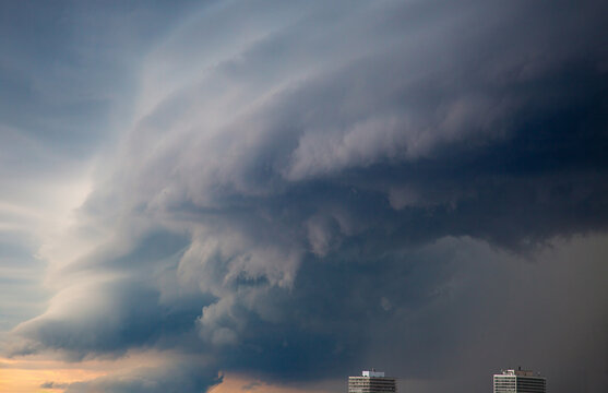 Aerial view of dramatic storm clouds and a shelf cloud formation looming over urban high-rise buildings in Toronto, Ontario, Canada.