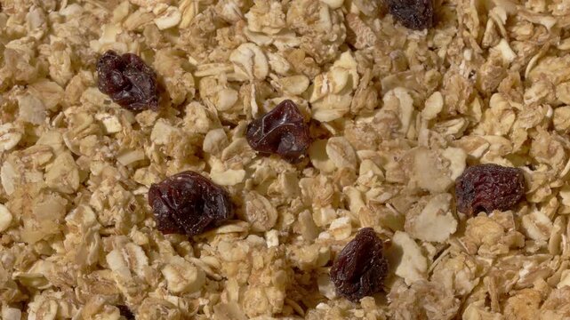 Rotating macro view of granola with rolled oats and raisins for healthy breakfast food and snacks.