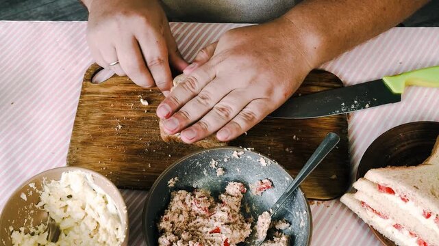 A man prepares a salad with tuna and egg