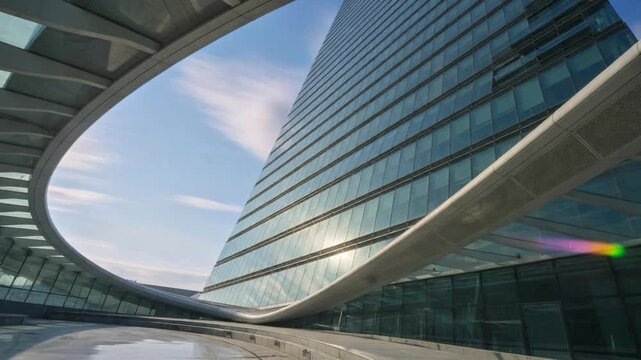 Low Angle View of Modern Glass Skyscraper Reflecting Sunlight Through Contemporary Architectural Frame