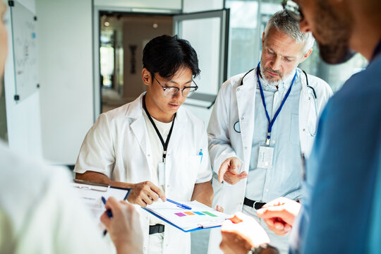 Doctors collaborating on patient case in hospital corridor