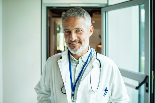 Smiling male doctor standing in hospital doorway