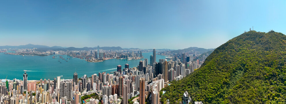 Wide panoramic aerial views of the cityscape and forested hills with cliffs and Hong Kong Bay