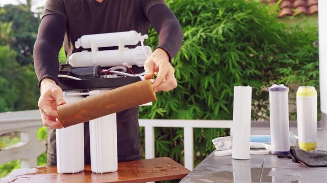 Cinematic Close Up of Used Reverse Osmosis Water Filter Cartridge Removed From Purification System During Maintenance Procedure