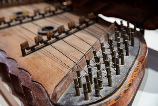 Close-up of the intricate strings and wooden body of a Dan Tam Thap Luc, a traditional Vietnamese hammered dulcimer