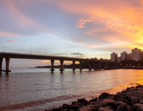 Golden sunset over Mumbai bridge with glowing skyline and calm waters