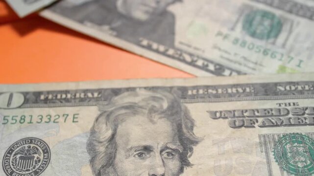 Three twenty-dollar bills lie on an orange background inside a currency exchange and a bank. Concept of economics and the stock market