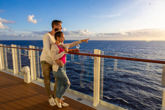 Romantic couple enjoying sunset on luxury cruise ship deck