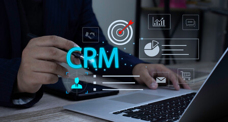 Naklejka premium Businessman using laptop for digital business strategy. Platform CRM interface icons showing customer data management, communication tracking, and sales performance.