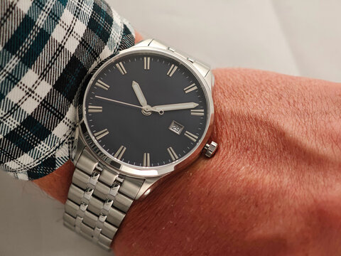 Modern Everyday Men&rsquo;s Watch with Metal Band. Man wearing a modern analog wristwatch with a clean black face and brushed metal strap