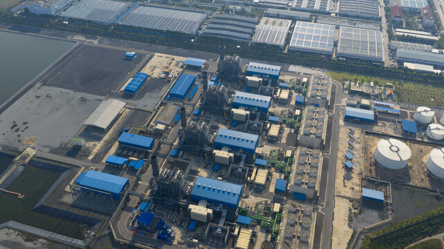 Aerial view of the Gulf Pluak Daeng Power Plant industrial complex with blue-roofed buildings and tall chimneys in Map Yang Phon, Rayong, Thailand.