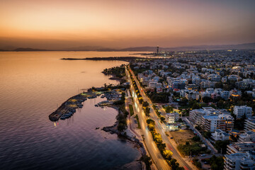 Fototapeta premium Aerial view of the southern coast of Athens, Greece, with Voula district, boat marinas and street traffic during dusk