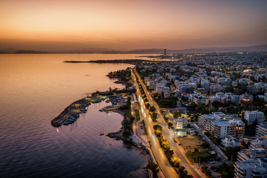 Aerial view of the southern coast of Athens, Greece, with Voula district, boat marinas and street traffic during dusk