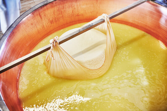 freshly formed parmesan curd from a large copper cauldron, a traditional technique used in creating Parmigiano Reggiano, Parma, Italy, Europe