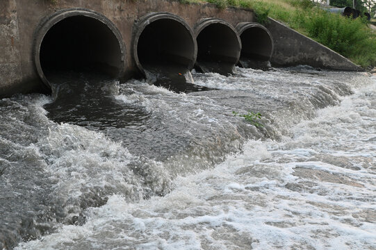 Wastewater Discharge Flowing from Concrete Drainage Pipes into Canal