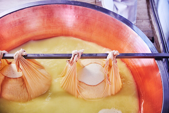 freshly formed parmesan curds from a large copper cauldron, a traditional technique used in creating Parmigiano Reggiano, Parma, Italy, Europe