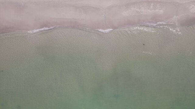 Overhead drone shot of jet skis near shallow tropical beach shoreline