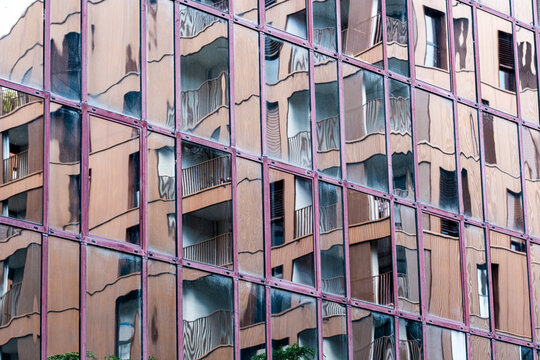 pink glass facade reflection ripples across office windows in urban architecture, creating exterior pattern blocks over a warm abstract surface