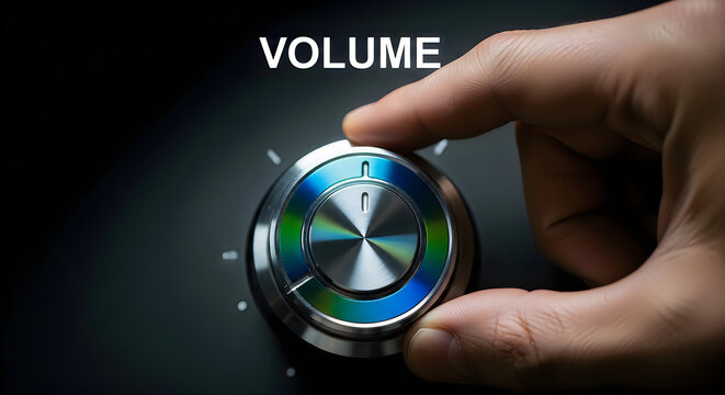 Close-up of a hand turning a shiny metallic volume knob with colorful blue and green accents