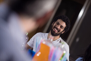 Obraz premium Middle Eastern man smiling during Eid Ramadan iftar dinner with modern family at home