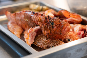 Close-up of fresh lionfish (Pterois) prepared for cooking on a metal tray. © Vladyslav