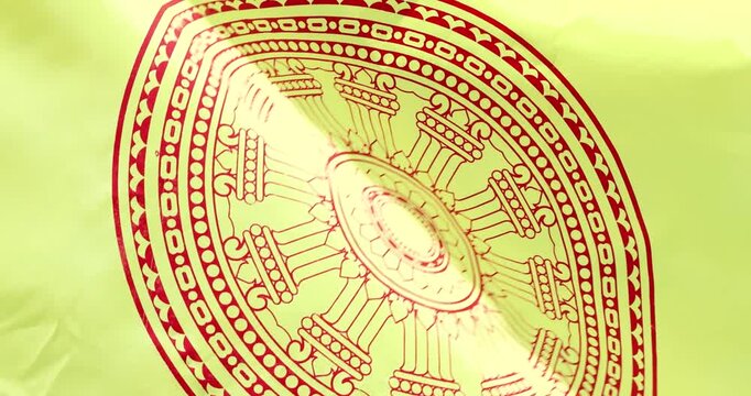 Buddhist flag with Dharmachakra symbol waving in the wind representing faith, Buddhist yellow flag, spirituality, peace, meditation and religious cultural concept, close-up