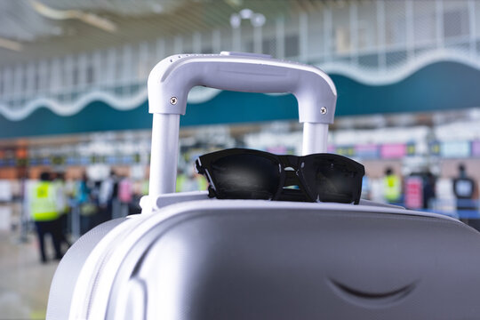 travelling suitcase, travel luggage with sunglasses at airport terminal