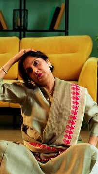 Indian senior couple doing stretching exercise or yoga at home in the morning performing neck, shoulder and wrist warmup with sukshma yogic kriya for joints in modern living room