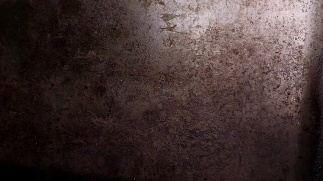 Oxidized baking sheet with charred spots and vintage brown surface. Abstract worn metal backdrop featuring heat damage. Rugged grunge texture
