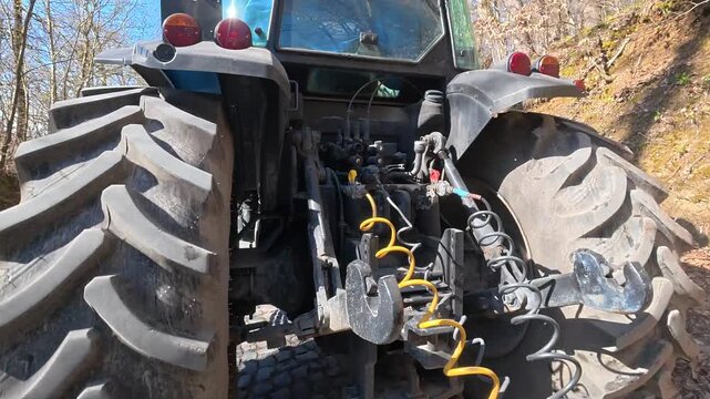 Rear view of a farm tractor, tractor on the road, big tractor wheels close-up